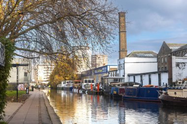 Londra, İngiltere - 10 Aralık 2022, Londra kentsel kral naibi kanalı manzarası, eski moda uzun kanal tekneleri ve modern şehir mimarisinin yer aldığı İngiltere