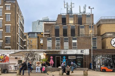Londra, Uk - 17 Aralık 2022, İnsanlar kaldırımda otururken sokak yemekleri yiyorlar. Brick Lane alanı.