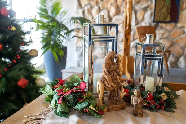 Church decoration for Christmas. Figurine of the Virgin Mary on a donkey and angels. Lamp on the background of spruce.
