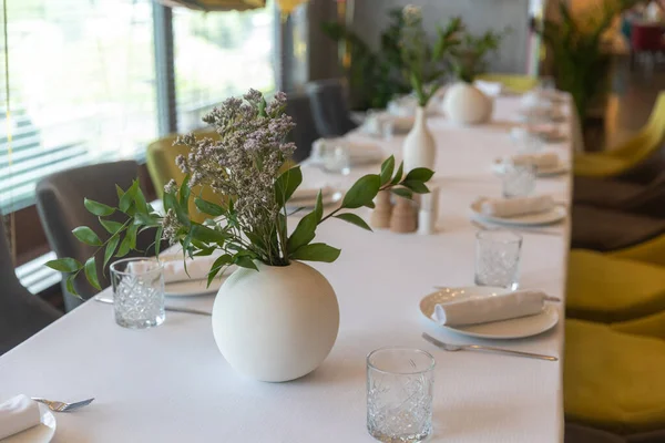 在一个圆圆的白色花瓶里烘干的花朵作为婚宴的餐桌装饰 餐具和眼镜 — 图库照片