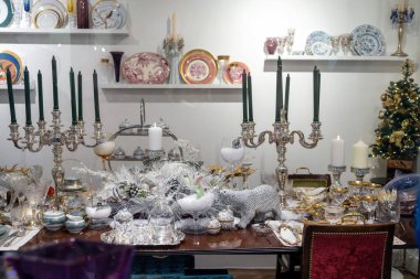 Londra, İngiltere - 23 Aralık 2022, Regent Caddesi 'ndeki Liberty mağazasının içi. İçinde porselen, kuru gümüş çiçekler, mumlar, leopar heykelcikleri olan beyaz masa örtüsü. Noel için dekore edilmiş..