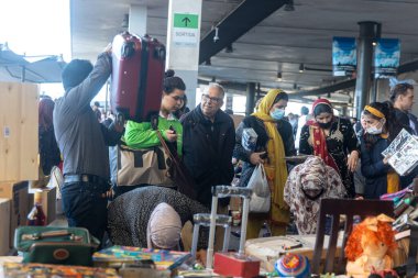BARCELONA - 14 Mart 2023: Placa de les Gloriesa 'daki Els Encants bit pazarındaki tipik tezgah. Kadınlar çekmeceleri karıştırıyor..