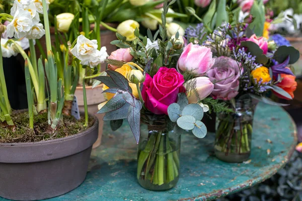 春暖花开的新娘花束 红玫瑰 郁金香 装在铁桌上的玻璃瓶里 — 图库照片