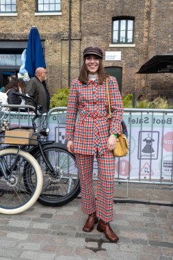 London UK - 15 Nisan 2023: Klasik araba bot satışı. Retro festivali. İnsanlar klasik giysiler, mücevher, klasik araçlarında ev eşyaları satıyorlar. 50 'lerin tarzı. kırmızı ekose takım elbise