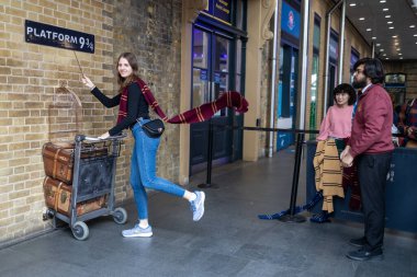 LONDON, ENGLAND - 15 Nisan 2023 Harry Potter hayranı bir tramvayı filmden 9. ve 3. platforma doğru itiyor.