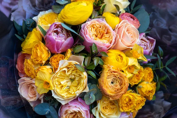 Pink,yellow and orange peony roses with eucalyptus in a wedding bouquet. View from above