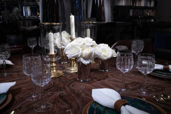 婚礼装饰 桌上的水晶花瓶里有一朵白玫瑰 烛台上的白色蜡烛 木制漆桌上的酒杯 — 图库照片
