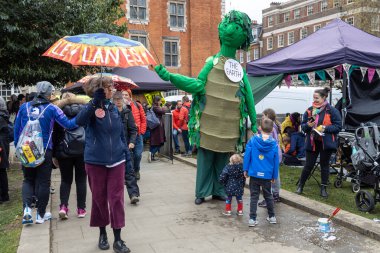 Londra, İngiltere -22.04.2023, yazıtlı parlak şemsiyeli göstericiler - gezegeni kurtarın. Üzerinde 