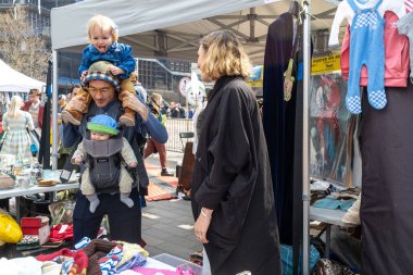 London UK - 15 Nisan 2023: Vintage 'dan Car Boot Sale. Retro festivali. İki çocuklu bir adam. Bir çocuk askıda, ikincisi boynunda oturuyor..