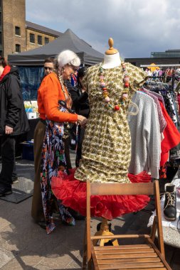 London UK - 15 Nisan 2023: Vintage 'dan Car Boot Sale. Retro festivali. İnsanlar klasik giysiler, mücevherler, klasik araçlarında ev eşyaları satıyorlar. Rockabilly tarzı giyinmiş kızlar