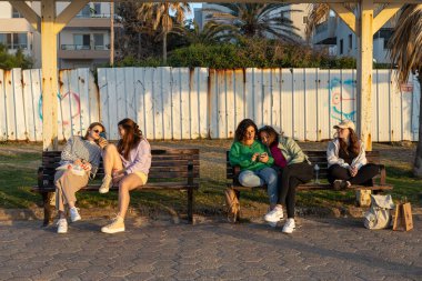 Hayfa, İsrail - 10 Mayıs 2023, Bat Galim plajı. Gezinti güvertesi. İnsanlar deniz havasını sever. Yürürler, birbirleriyle iletişim kurarlar, çocuklarla oynarlar, arkadaşlarıyla banklarda otururlar. Denizi seviyorlar..