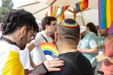 Hayfa, İsrail - 24 Haziran 2023: Geleneksel LGBTQ onur yürüyüşü için protesto tabelaları taşıyan insanlar. Gökkuşağı kippah içinde bir adam