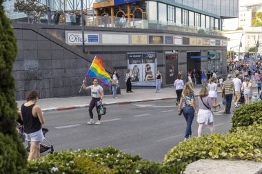Hayfa, İsrail - 24 Haziran 2023: Geleneksel LGBTQ onur yürüyüşü için protesto tabelaları taşıyan insanlar. Gökkuşağı bayrağı sallayan kız