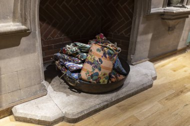 Ev dekorasyonu için şöminenin yanında çok renkli yastıklı bir leğen.