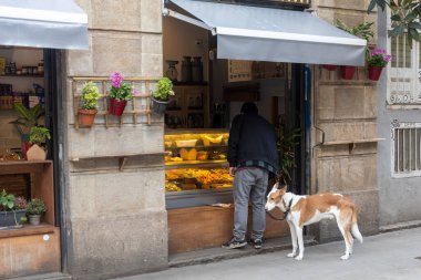Barselona, Katalonya, İspanya - 29 Mart 2023: Köpekli bir adam Çin yemek standında yiyecek seçiyor.