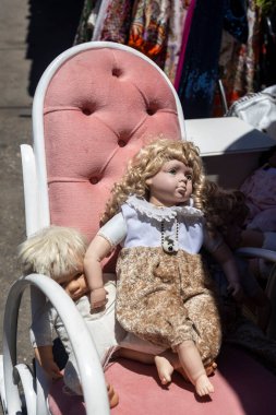 Hayfa, İsrail -20 Temmuz 2023, Antik Cumartesi pazarı eski bölgede. Eski püskü oyuncak bebek güneşli bir günde eski püskü bir koltukta oturur.
