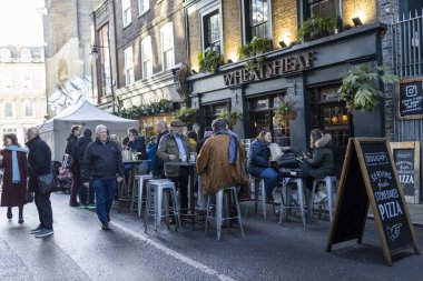 Londra, İngiltere - 10 Aralık 2023, Londra 'nın güzel sokakları ve caddelerinde işten sonra saat 5' te içki içilen insanlar. Buğday püskülü.