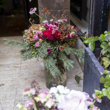 Bir buket köknar, kırmızı güller, ranunculus, ortanca ve böğürtlen. Ivy ön planda. Noel için dekorasyonlar.