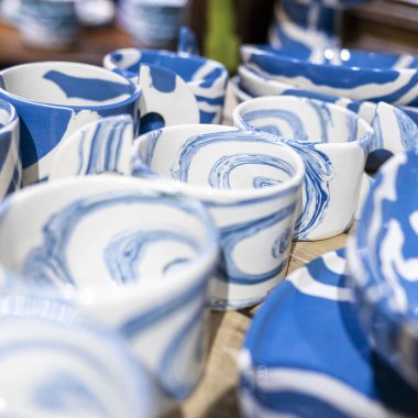 Çok çeşitli beyaz tabak ve kupalar dizilmişti.