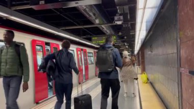 Barselona, İspanya - 24 Nisan 2024, Metro, insanlar arabadan inip çıkışa gidiyor. Tren kalkıyor. Arkadan insanların görüntüsü.