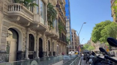 Barselona, İspanya - 24 Nisan 2024, balkonunda palmiye ağaçları ve tropik bitkiler bulunan Art Nouveau binası.