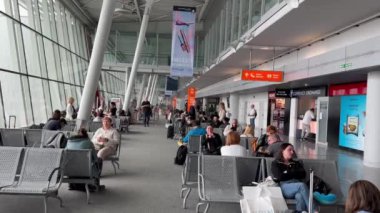 Varşova, Polonya - 4 Nisan 2024: İnsanlar Varşova Chopin Havaalanı 'ndaki uçuşları için uçağa binmek için bekliyor