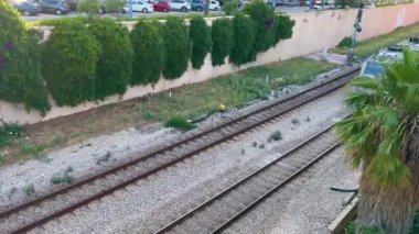 Hayfa, İsrail - 20 Mayıs 2024, Tel Aviv 'e giden kırmızı çift katlı tren Hayfa' daki Leonardo Sahili 'ndeki rayları takip ediyor. Yukarıdan görüntüle.