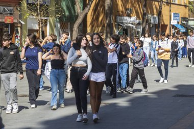 Valencia, İspanya - 20 Nisan 2024. Ergenlik çağındaki okul çocukları eski şehri geziyorlar. Arkadaşlar sarılıyor..