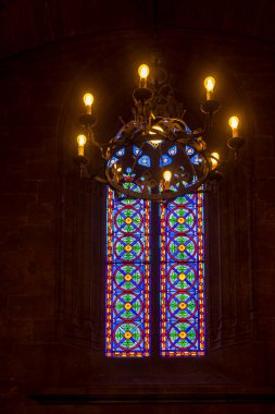 Valencia, Spain - 20 April 2024. Stained glass window with chandelier in the interior of the Silk Exchange. clipart