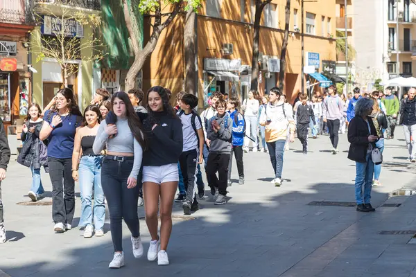 stock image Valencia, Spain - April 20, 2024. Teenagers schoolchildren on a tour of the old city. Friends hugging.