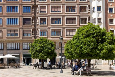 Valencia, İspanya - 05 05: 2024: İnsanlar eski bir meydanın yakınındaki bir kafede oturuyor.