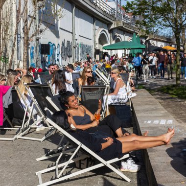 Berlin, Almanya - 02 Nisan 2024. İnsanlar Berlin 'deki setin kenarındaki bir kafede güneşleniyorlar..