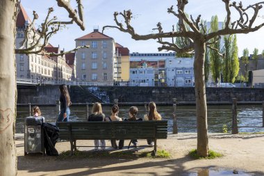 Berlin, Germany - May 2, 2024, People sitting by the canal by the water, picnic. Opposite the museum island. clipart