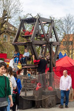 Berlin, Almanya - 30 Mart 2024: Ortaçağ Fuarı: Çocuklar eski ahşap bir atlıkarıncayı taklit ediyorlar.