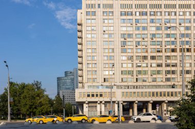Moskova, Rusya - 16 Temmuz 2024, Serpukhovskaya metro istasyonu yakınlarındaki yüksek katlı kütüphane binasının yanında sarı taksiler