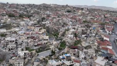 Kapadokya, Türkiye -24 Nisan 2024, Ortahisar şehri ön planda caminin minaresi ve arka planda Goreme kasabası yakınlarındaki Kapadokya vadisi yer almaktadır.,