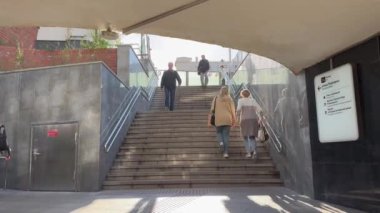 Moskova, Rusya - 12 Ağustos 2024. İnsanlar - erkekler ve kadınlar Puşkinskaya istasyonunun önündeki metro girişine doğru iniyorlar..