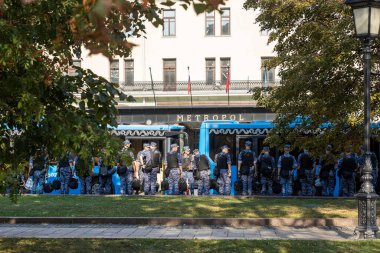 Moscow, Russia - August 26, 2024. Rosgvardiya officers and soldiers stand near the buses that brought them, for maintaining order, opposite the Metropol Hotel. clipart