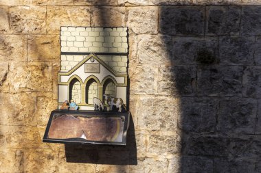 Zichron Yaakov, İsrail. 12 Kasım 2024. Bilgi Turizm Merkezi 'ndeki taş duvarda çiftçi ve inek figürleri..