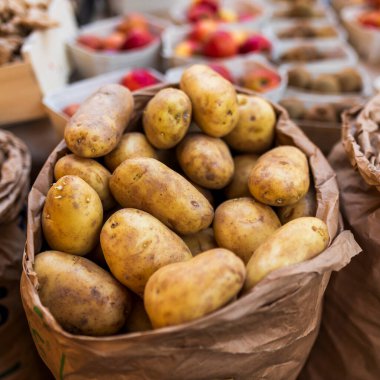 Pazarda satılık patates filizli kağıt bir torba. Kare kare