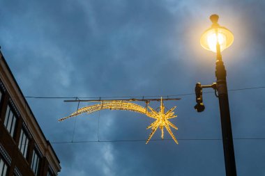 Londra, İngiltere, 22 Kasım 2024. Seven Dials caddesinde alacakaranlıkta ışıklar kayan yıldız ve fener şeklinde..