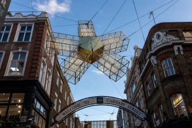Londra, İngiltere - 29 Kasım 2024. Carnaby Caddesi 'ndeki ışık süslemeleri günbatımı gökyüzünün arka planına karşı çiçek şeklinde..