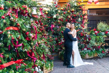 Londra, İngiltere - 29 Kasım 2024. Gelin ve damat, Covent Garden 'daki Noel süslemelerine karşı poz veriyor..