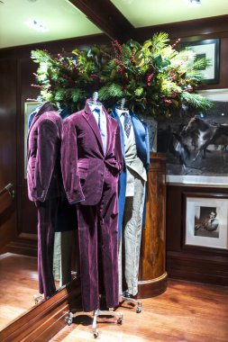 Londra, İngiltere - 2 Aralık 2024: Ralph Lauren 'in Noel penceresinde mor ve sarı kadife takımlı mankenler içeren büyük köknar dalları ve şahin çilekleri yer almaktadır..