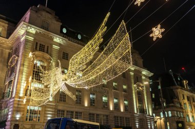 Londra, İngiltere - 2 Aralık 2024: Noel ışıkları. Gökyüzüne ve binalara karşı Regent Caddesi 'nde melek şeklinde bir süs..
