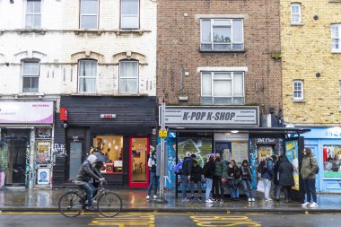  Londra, İngiltere - 2 Aralık 2024: Brick Lane otobüs durağında yağmurlu bir günde otobüs bekleyen insanlar.