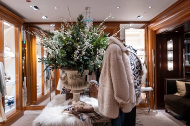 Londra, İngiltere - 1 Aralık 2024, Ralph Lauren mağazası. İç dekorasyon. Bir buket kar çileği ve büyük demir bir vazoda çam dalları, sahte kürk mankenler giymiş bir manken..