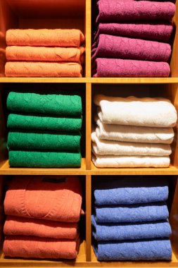 Kablolu örgü desenli parlak renkli yün ve kaşmir kazaklar bir gardıroptaki renklere göre dizilmiştir..