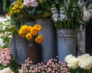 Beyaz Matthiola incana, güller, şeftali çiçekleri, sarı ranunculus, Veronica longifolia, Speedwell veya longleaf Speedwell, çiçek pazarında satılmak üzere çinko kovalarda. Tebrik kartı.