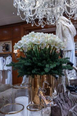 Londra, İngiltere 2 Aralık 2024, Ralph Lauren mağazasının içi Noel için dekore edildi. Bir buket suni köknar dalları ve beyaz amililli gri kadife çantalar, mumlu cam şamdanlar., 